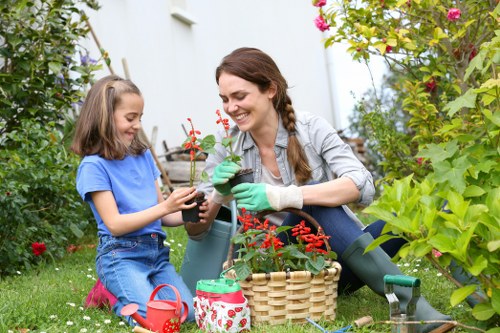 Workers planting in a sustainable Chiswick garden with recycling bins nearby